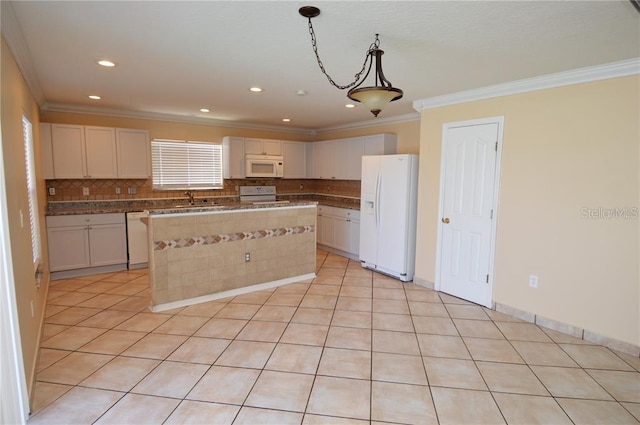 kitchen with backsplash, white appliances, white cabinetry, and a center island