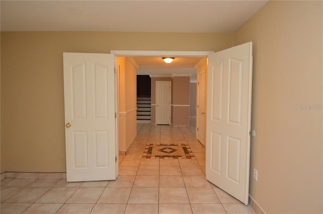 corridor featuring ornamental molding and light tile flooring