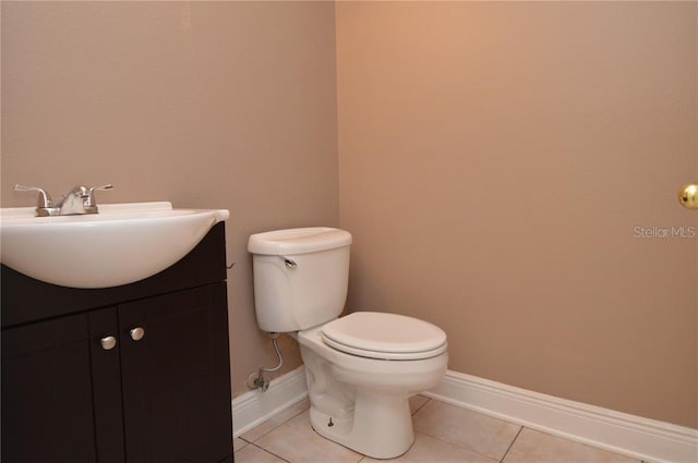 bathroom featuring toilet, vanity, and tile flooring