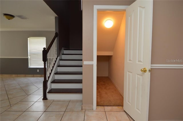 stairs with crown molding and light colored carpet