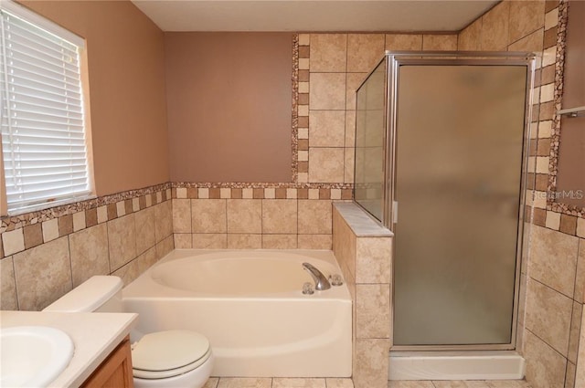 full bathroom featuring shower with separate bathtub, toilet, tile floors, and vanity