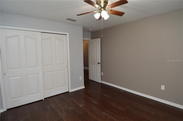 unfurnished bedroom with dark hardwood / wood-style floors, a closet, and ceiling fan