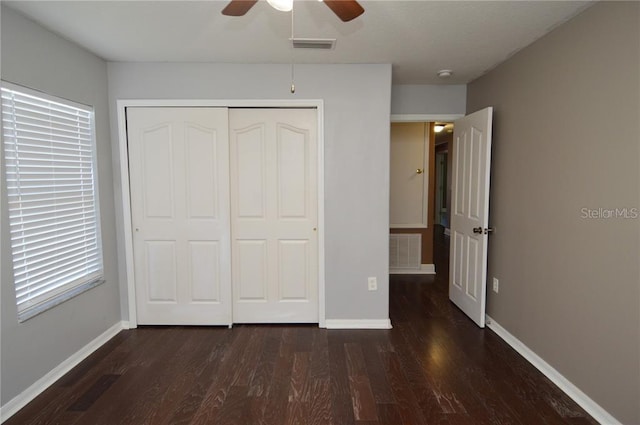 unfurnished bedroom featuring a closet, ceiling fan, and dark hardwood / wood-style floors