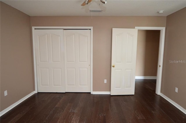 unfurnished bedroom featuring dark hardwood / wood-style floors, a closet, and ceiling fan