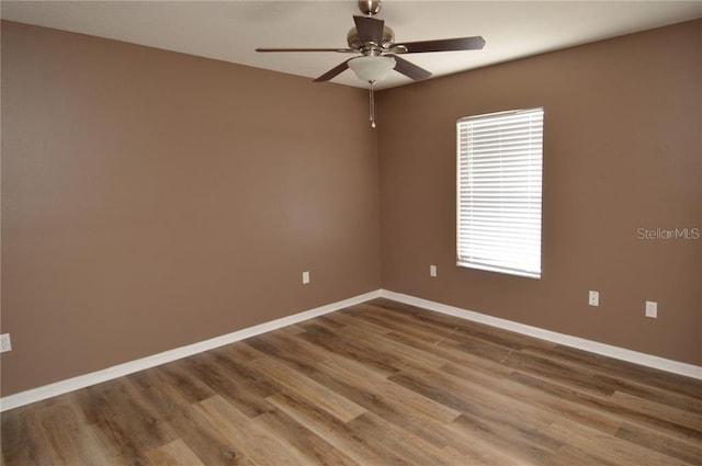 spare room with dark hardwood / wood-style flooring, a healthy amount of sunlight, and ceiling fan