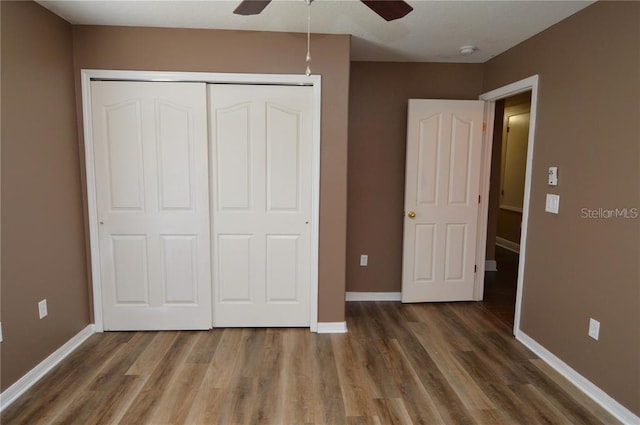 unfurnished bedroom with a closet, ceiling fan, and dark hardwood / wood-style flooring