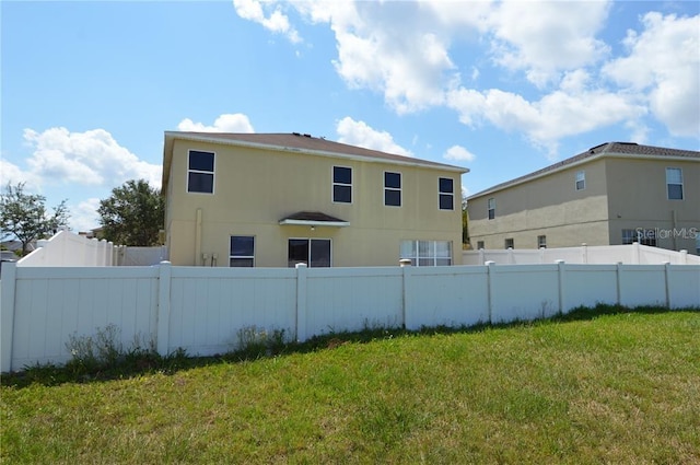 rear view of property featuring a yard