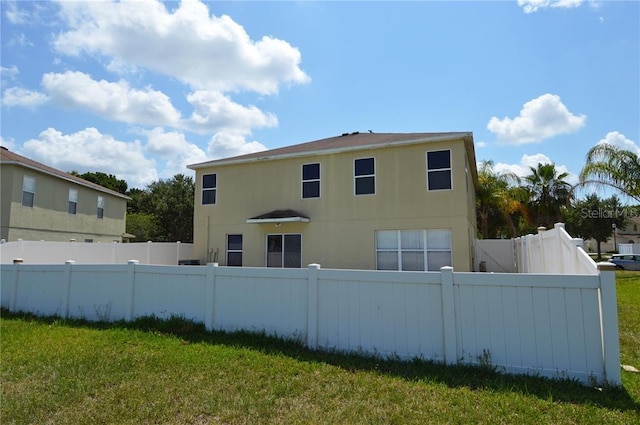 rear view of property featuring a lawn