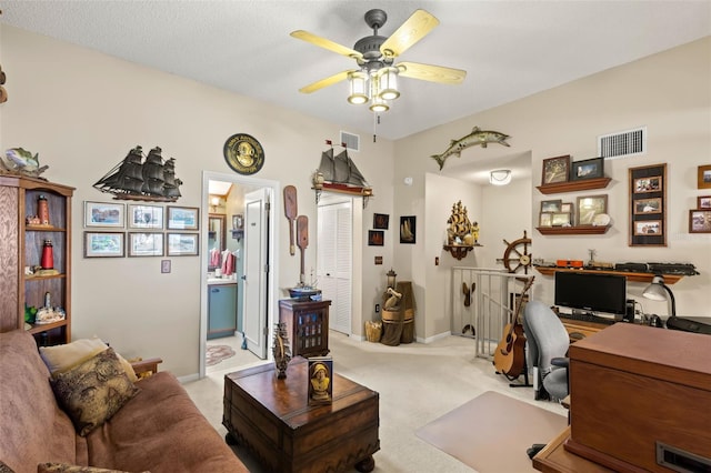 office space featuring light carpet, a textured ceiling, and ceiling fan