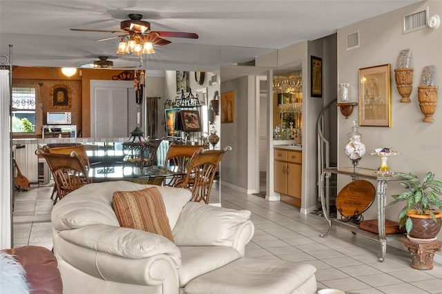 living room featuring light tile patterned floors and ceiling fan