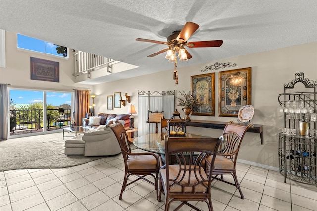 tiled dining room with a textured ceiling and ceiling fan