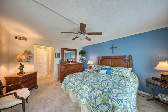 bedroom featuring ceiling fan, light colored carpet, ornamental molding, and a textured ceiling