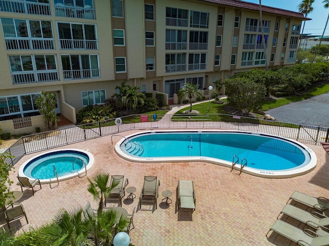 view of swimming pool featuring a community hot tub and a patio area