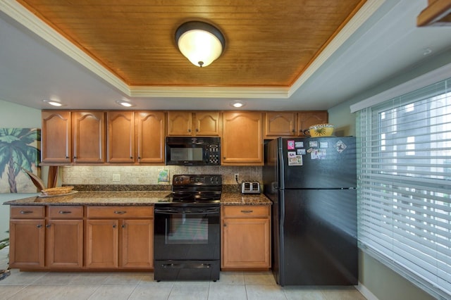 kitchen with black appliances, a raised ceiling, and dark stone counters