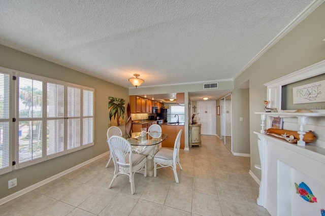 dining area featuring ornamental molding, sink, a textured ceiling, and light tile patterned floors