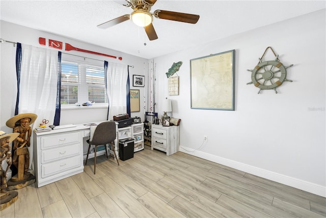 office area featuring ceiling fan, a textured ceiling, light wood-style flooring, and baseboards