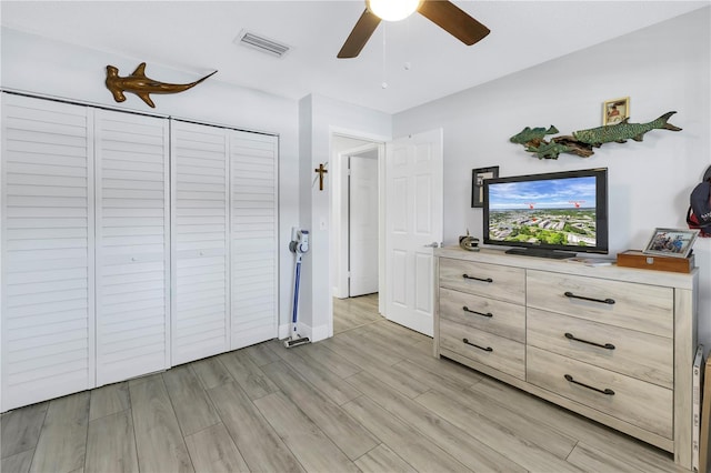 unfurnished bedroom featuring baseboards, visible vents, ceiling fan, wood tiled floor, and a closet