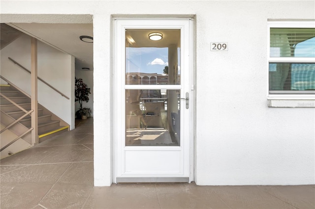 doorway to property featuring stucco siding