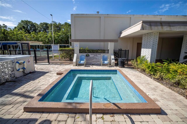 view of pool featuring a patio area, fence, and a community hot tub