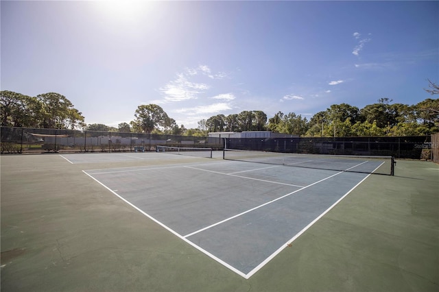 view of tennis court featuring fence