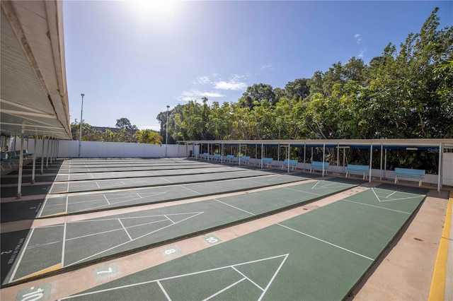 view of property's community with shuffleboard and fence