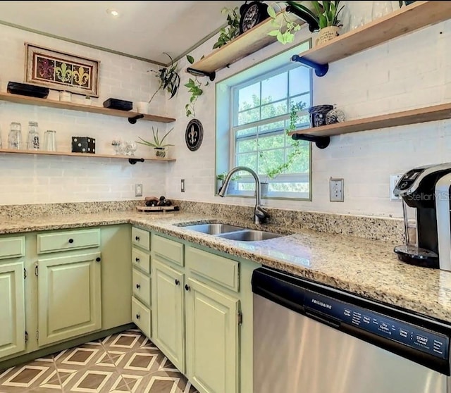 kitchen with light stone countertops, stainless steel dishwasher, and sink