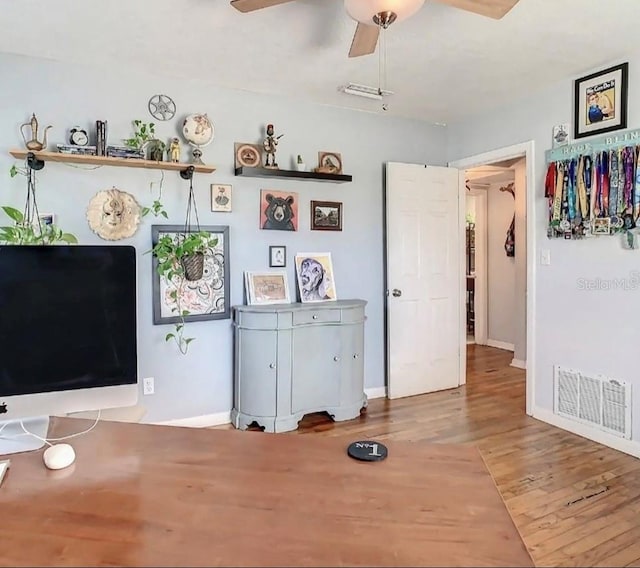 interior space featuring wood-type flooring and ceiling fan