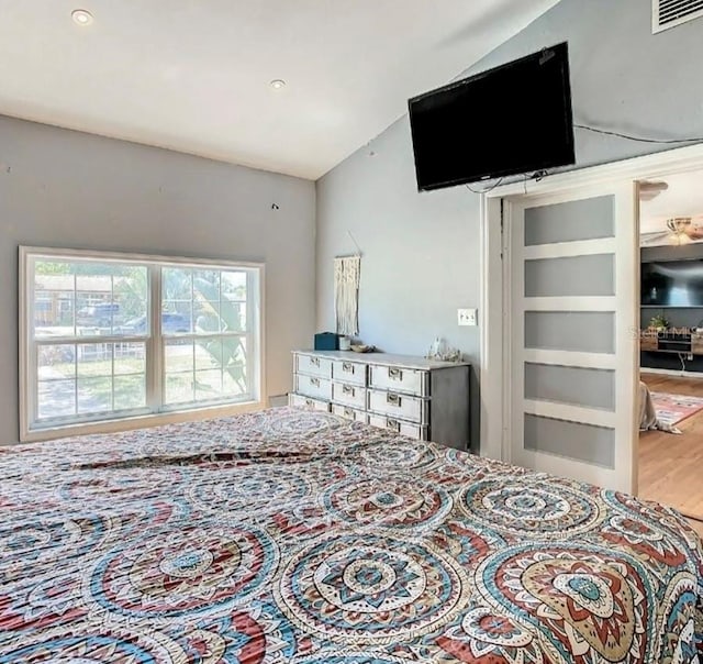 bedroom with hardwood / wood-style floors and vaulted ceiling