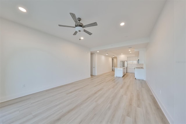 unfurnished living room featuring a ceiling fan, recessed lighting, light wood-style flooring, and baseboards