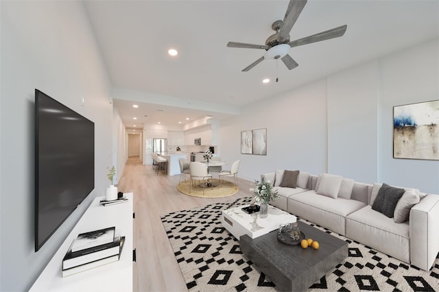 living room with light wood finished floors, a ceiling fan, and recessed lighting