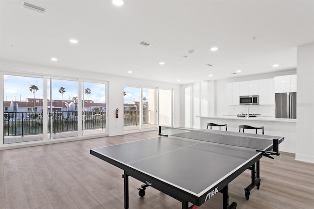 rec room featuring light wood-style flooring, recessed lighting, and visible vents