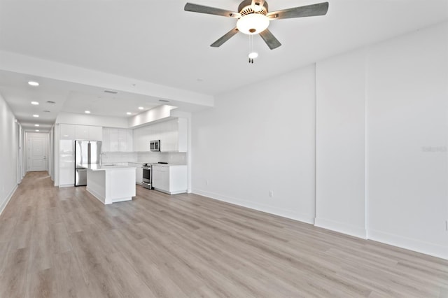 unfurnished living room with a sink, light wood-style floors, ceiling fan, and recessed lighting