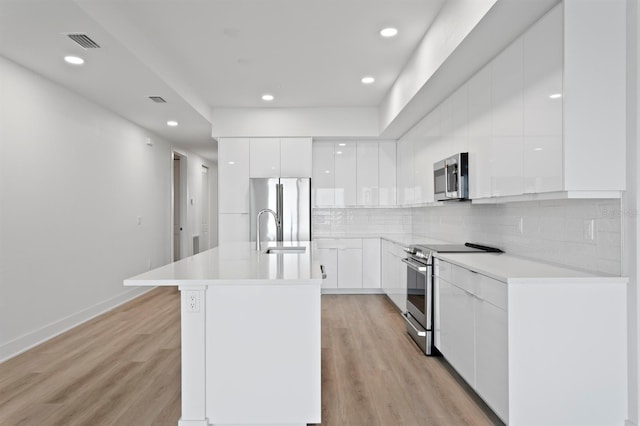 kitchen featuring a sink, white cabinetry, appliances with stainless steel finishes, modern cabinets, and light wood-type flooring