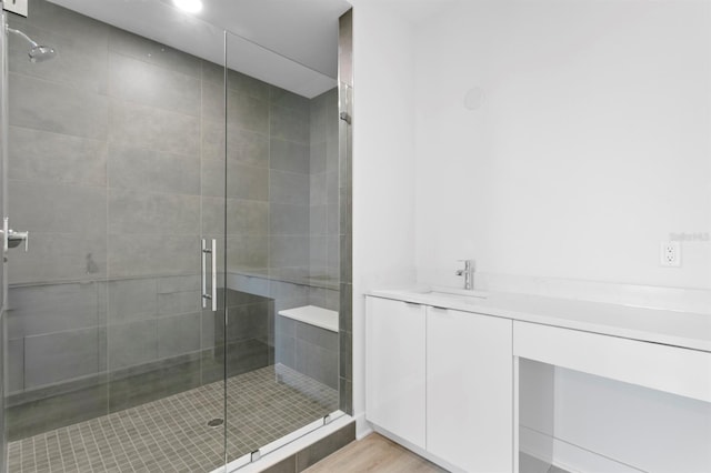 full bathroom with a sink, a stall shower, and wood finished floors