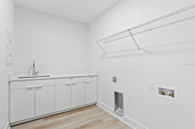 clothes washing area featuring hookup for an electric dryer, a sink, light wood-style floors, cabinet space, and washer hookup