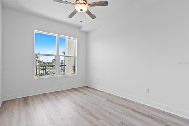 spare room with baseboards, ceiling fan, and light wood-type flooring