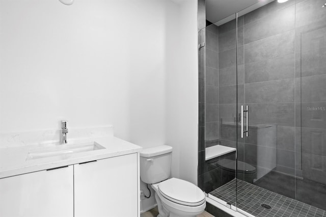 bathroom featuring a stall shower, toilet, and vanity