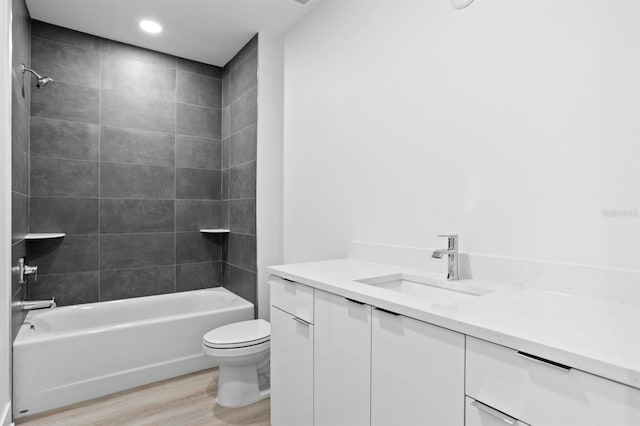 bathroom featuring toilet, wood finished floors, vanity, and bathing tub / shower combination