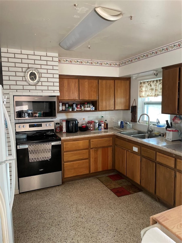 kitchen featuring decorative backsplash, appliances with stainless steel finishes, and sink