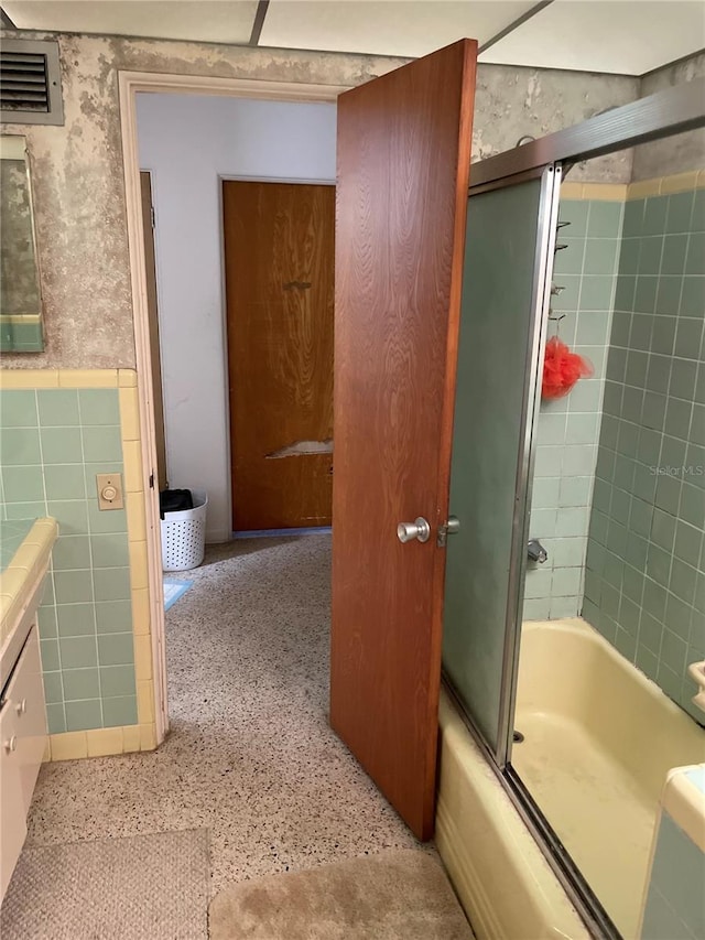 bathroom featuring vanity and combined bath / shower with glass door