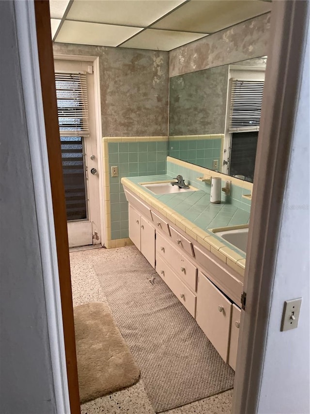 bathroom with vanity and tile walls