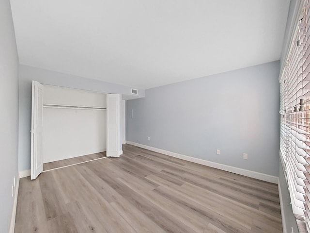 unfurnished bedroom featuring light hardwood / wood-style floors and a closet