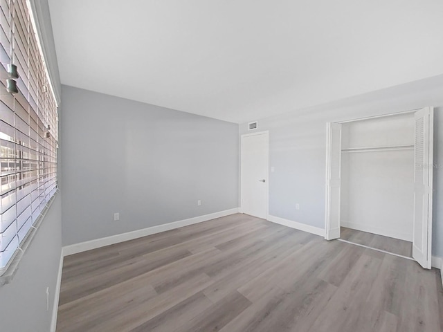 unfurnished bedroom featuring a closet and light hardwood / wood-style floors