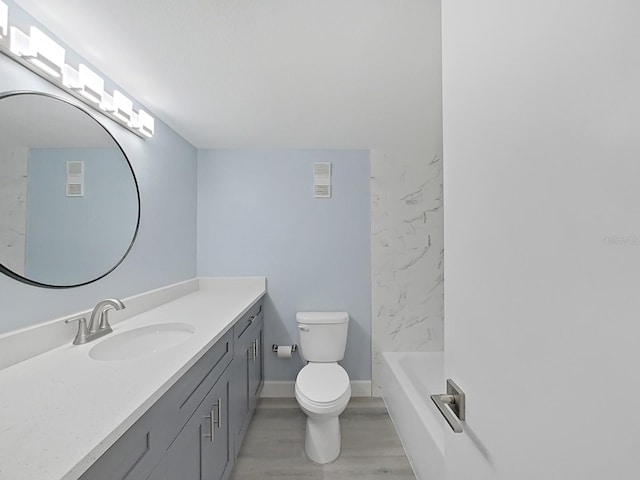 bathroom featuring wood-type flooring, toilet, and oversized vanity