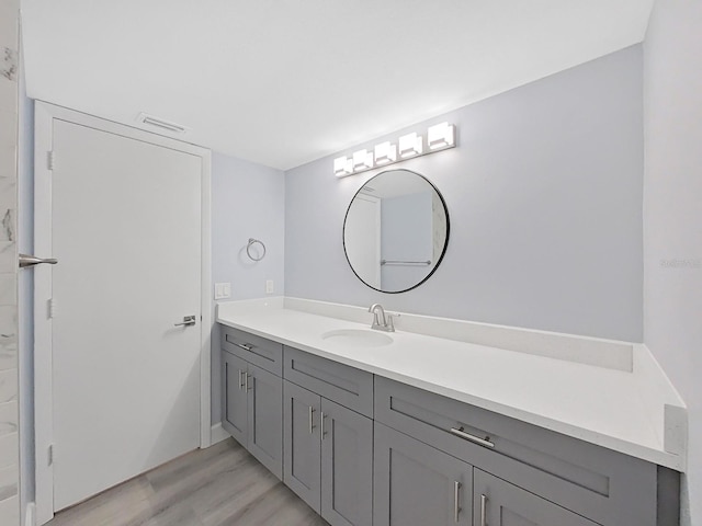 bathroom with vanity with extensive cabinet space and hardwood / wood-style floors