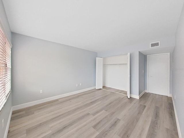 unfurnished bedroom featuring light hardwood / wood-style floors and a closet