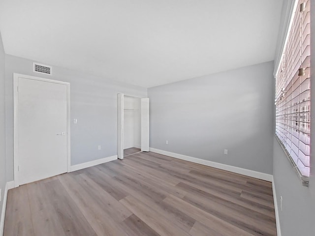 unfurnished room with hardwood / wood-style flooring