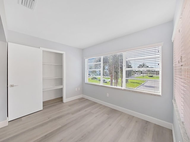 unfurnished bedroom with a closet and light wood-type flooring