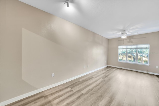 spare room with light wood-type flooring and ceiling fan