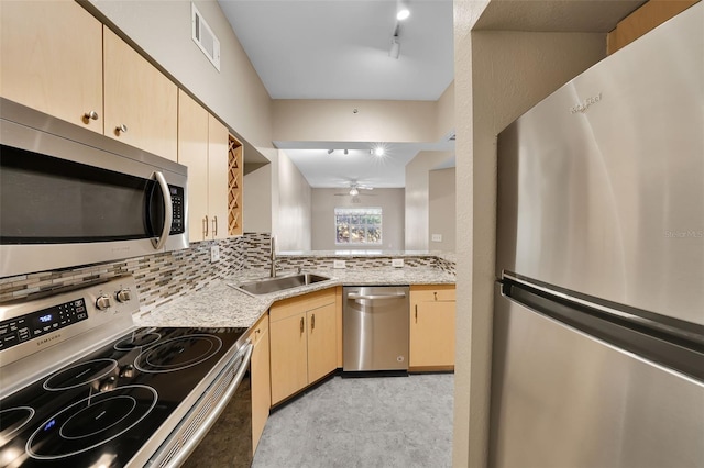 kitchen with ceiling fan, sink, light brown cabinets, light stone counters, and appliances with stainless steel finishes